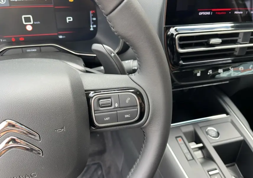 Intérieur du Citroën C5 Aircross Hybrid 2025, vue sur le volant avec commandes et tableau de bord numérique.