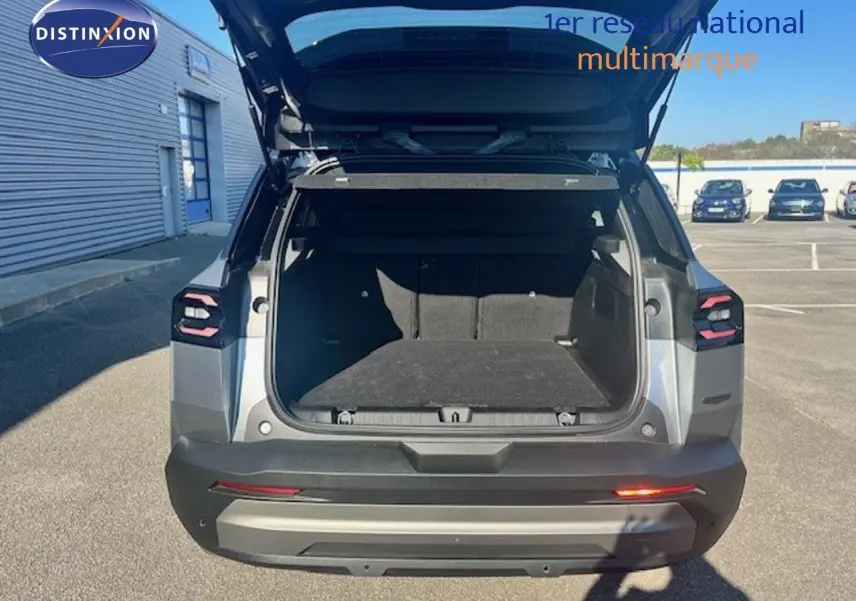 Vue arrière ouverte du Jeep Compass gris Yosemite métal avec coffre spacieux et toit noir visible en extérieur.