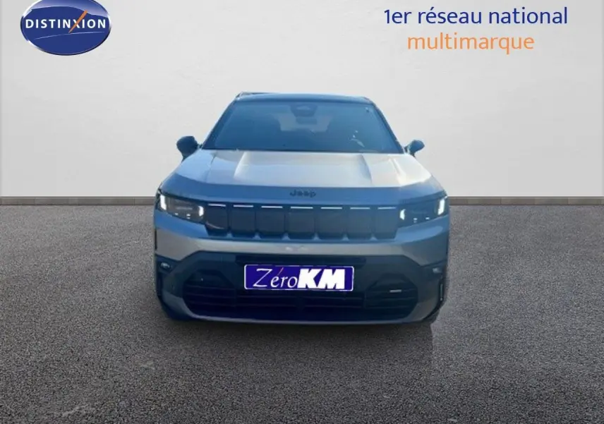 Vue frontale du Jeep Compass 2026 gris Yosemite métal avec toit noir, mettant en valeur sa calandre distinctive et ses phares LED.