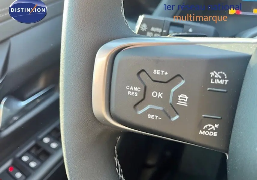 Gros plan sur les commandes de régulateur de vitesse au volant d’un Jeep Compass 2026 gris Yosemite métal avec toit noir.