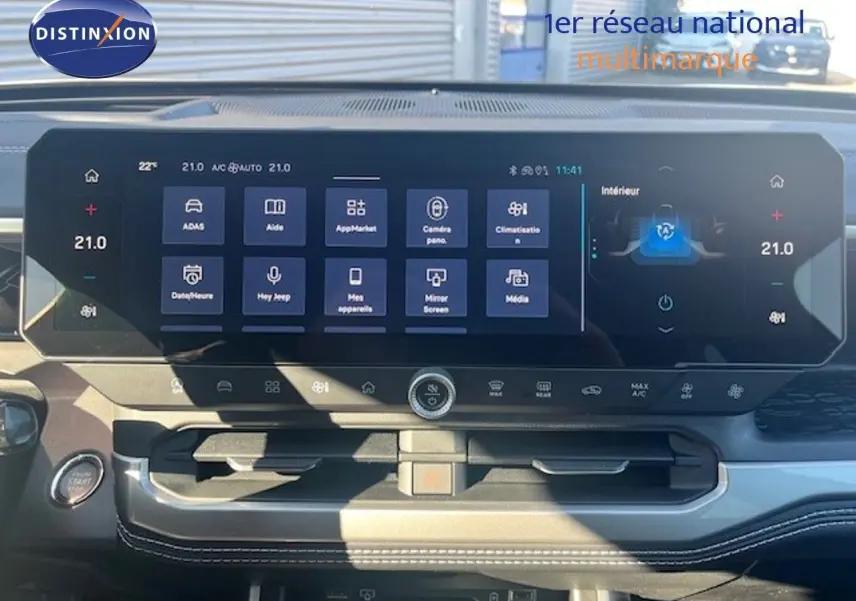 Vue intérieure du tableau de bord du Jeep Compass 2026, écran tactile large affichant les commandes de climatisation et multimédia.