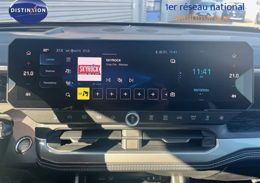 Vue intérieure du tableau de bord du Jeep Compass 2026 avec écran tactile large affichant la radio Skyrock et commandes climatisation.