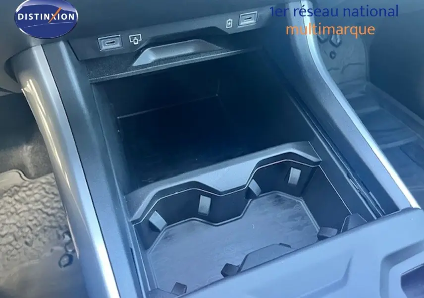Gros plan sur le rangement central et porte-gobelets noir à l’intérieur du Jeep Compass 2026 gris Yosemite métal avec toit noir.