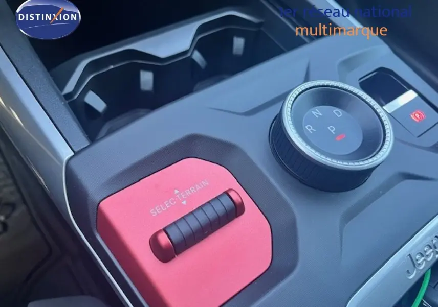 Gros plan sur la console centrale du Jeep Compass 2026 avec molette de boîte auto et sélecteur de terrain rouge.