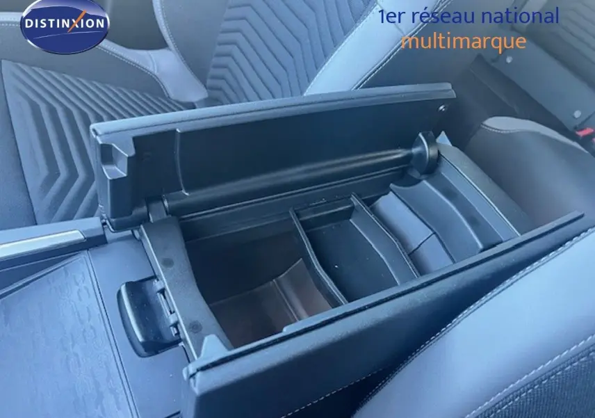 Vue rapprochée de l'accoudoir central ouvert et compartimenté dans l'habitacle noir du Jeep Compass 2026.