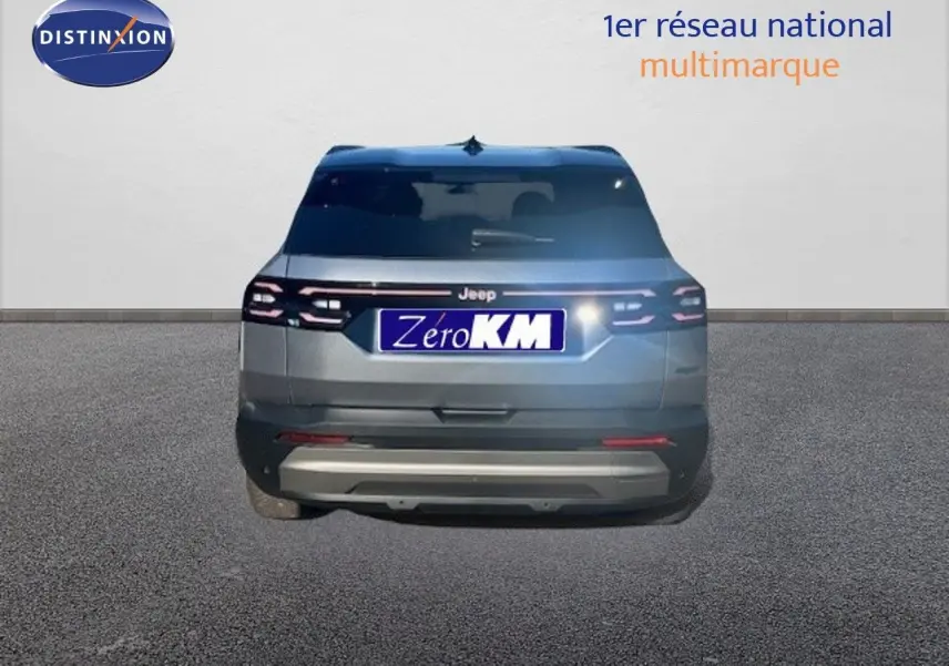 Vue arrière d'un Jeep Compass 2026 gris Yosemite métal avec toit noir, feux arrière LED allumés sur fond neutre.