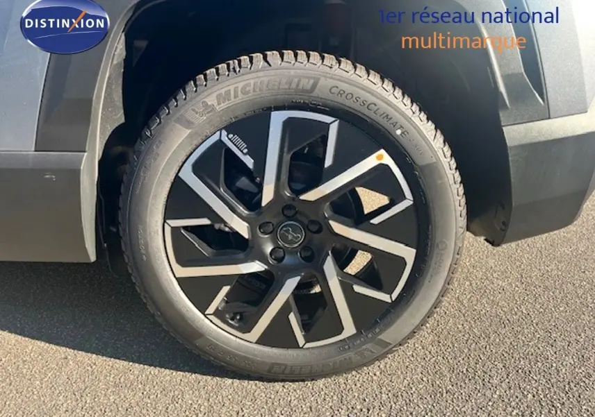 Gros plan sur la roue avant droite du Jeep Compass gris Yosemite avec jante noire et détails argentés.