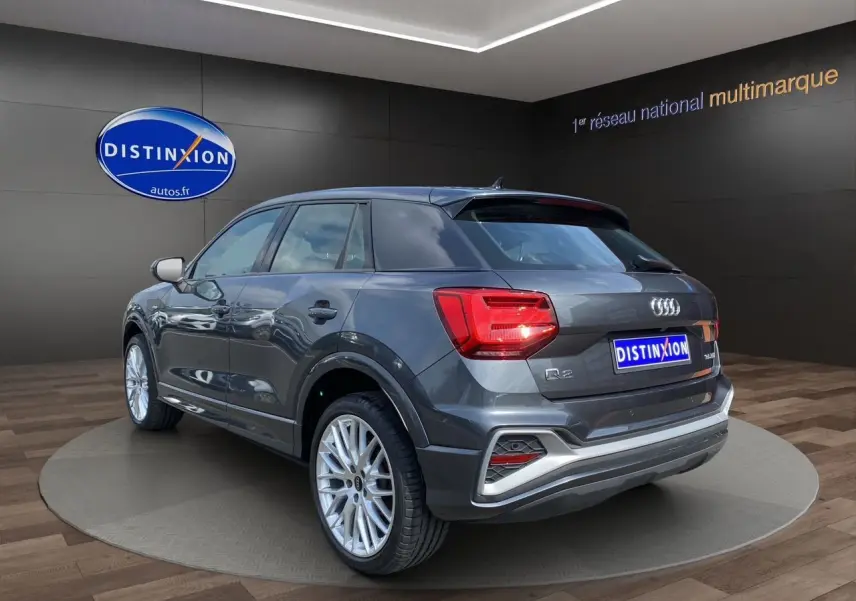 Audi Q2 gris Daytona en 3/4 arrière droit, avec jantes aluminium 19 pouces et feux arrière LED distinctifs.