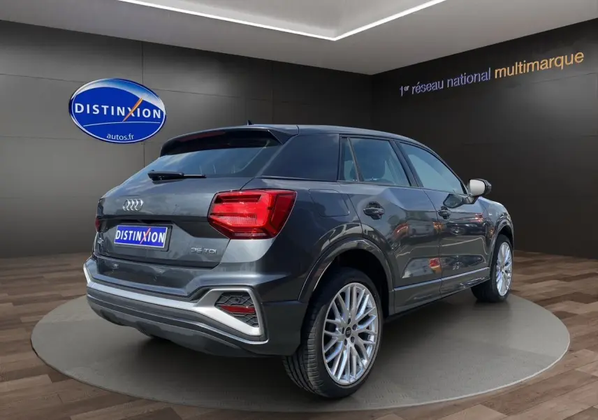 Audi Q2 gris Daytona en 3/4 arrière droit, avec feux LED et jantes aluminium Audi Sport 19 pouces visibles.