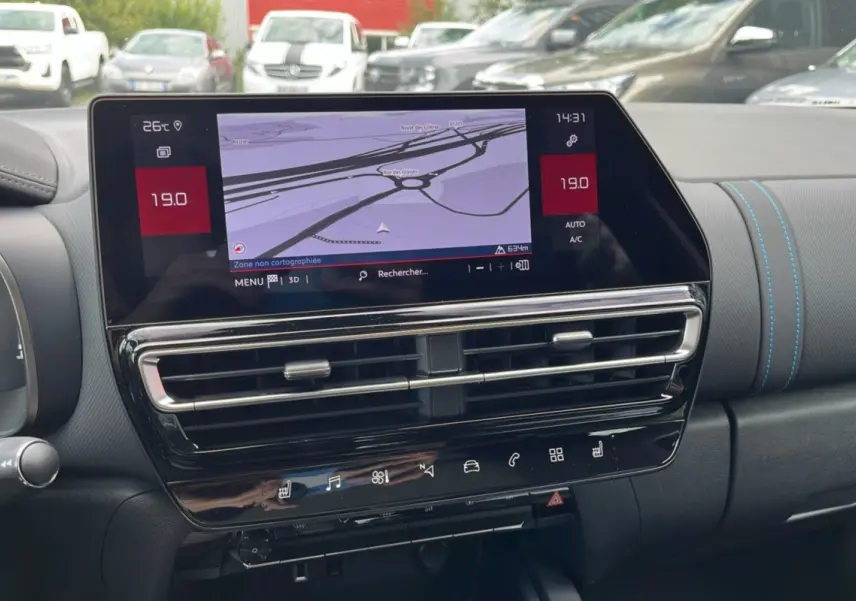 Tableau de bord du Citroën C5 Aircross Hybrid 2025 avec écran tactile et coutures bleues sur le tableau de bord.