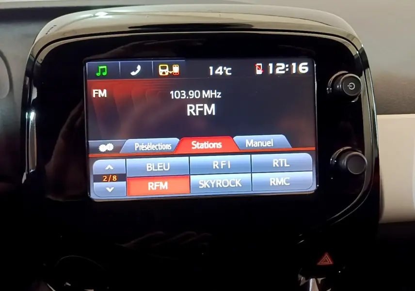 Écran tactile central de la Peugeot 108 rouge 2017 affichant les stations radio FM avec interface claire.
