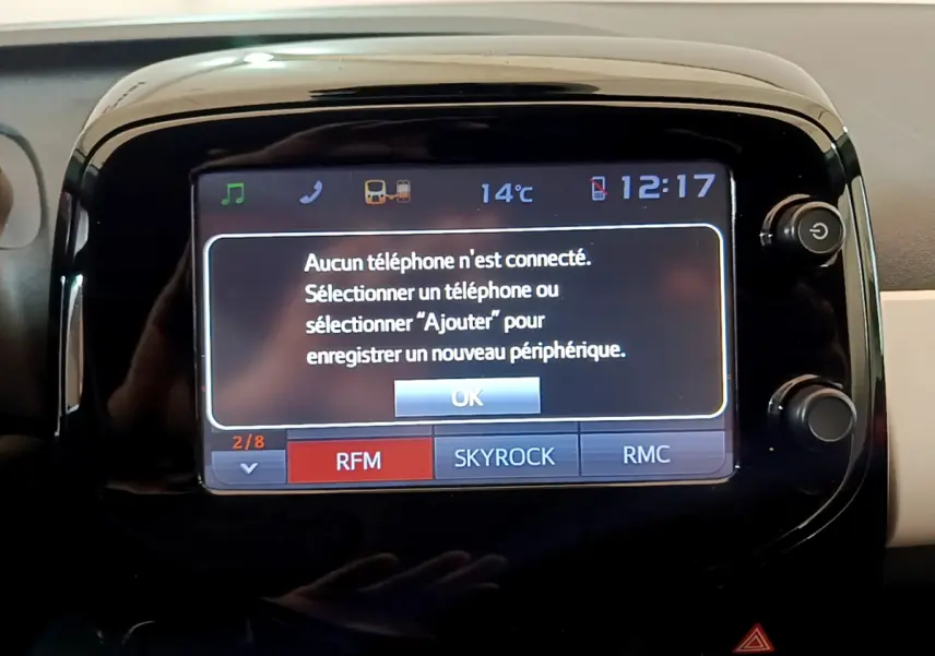 Écran tactile central affichant la connexion Bluetooth inactive dans l'habitacle d'une Peugeot 108 rouge.