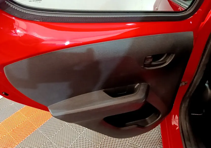 Vue rapprochée de la porte arrière gauche rouge d'une Peugeot 108 2017, avec garniture noire et poignée intégrée.