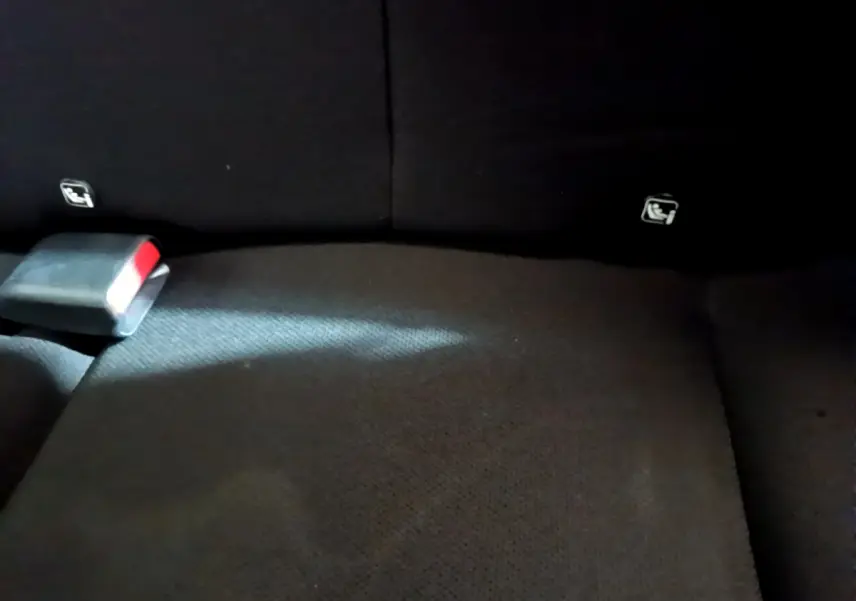 Gros plan sur la banquette arrière noire du Peugeot 108 2017, avec ceintures de sécurité visibles.