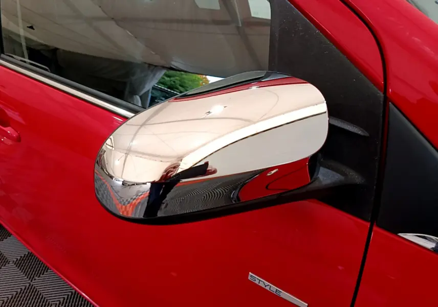 Rétroviseur chromé côté gauche d'une Peugeot 108 rouge version Style 2017, avec porte et badge visibles.
