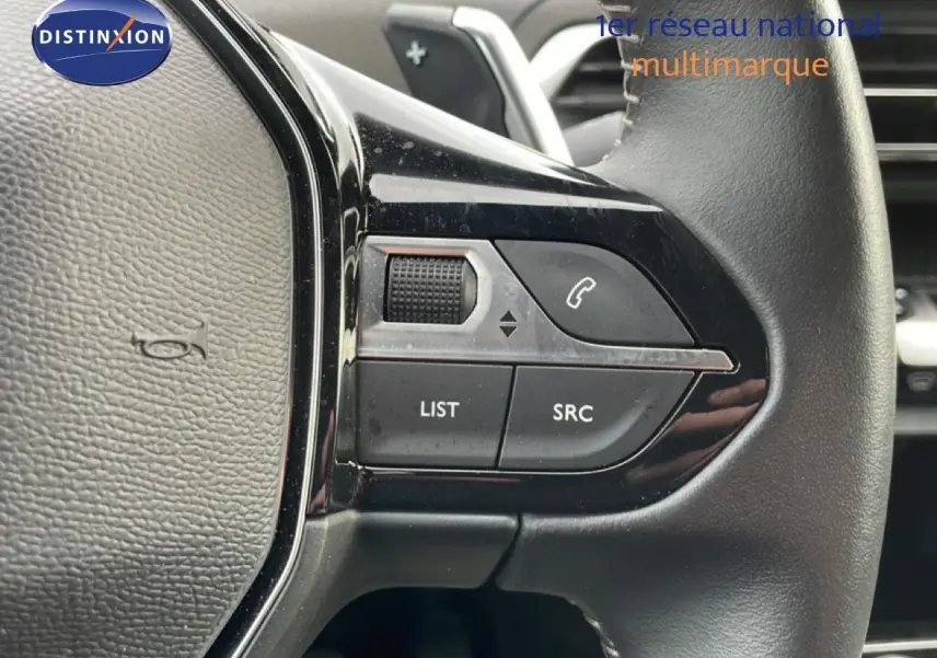 Gros plan sur les commandes gauche du volant du Peugeot 3008 2024, finition Allure Pack, intérieur noir.