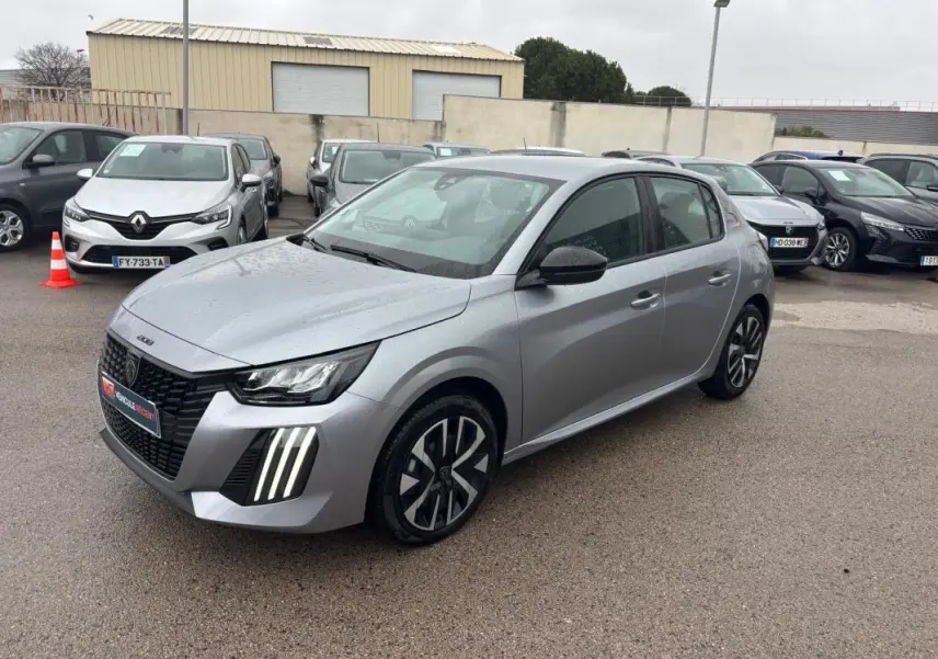 Peugeot 208 Hybrid gris vue 3/4 avant droit, feux LED diurnes verticaux et jantes 16 pouces stylisées.