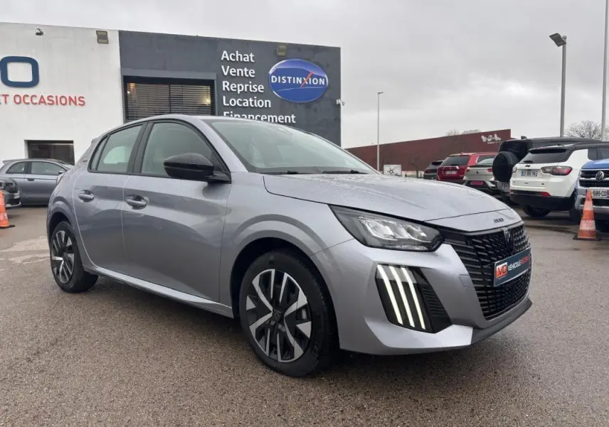 Peugeot 208 Hybrid gris vue 3/4 avant droit, avec feux diurnes à LED verticaux et jantes 16 pouces stylisées.