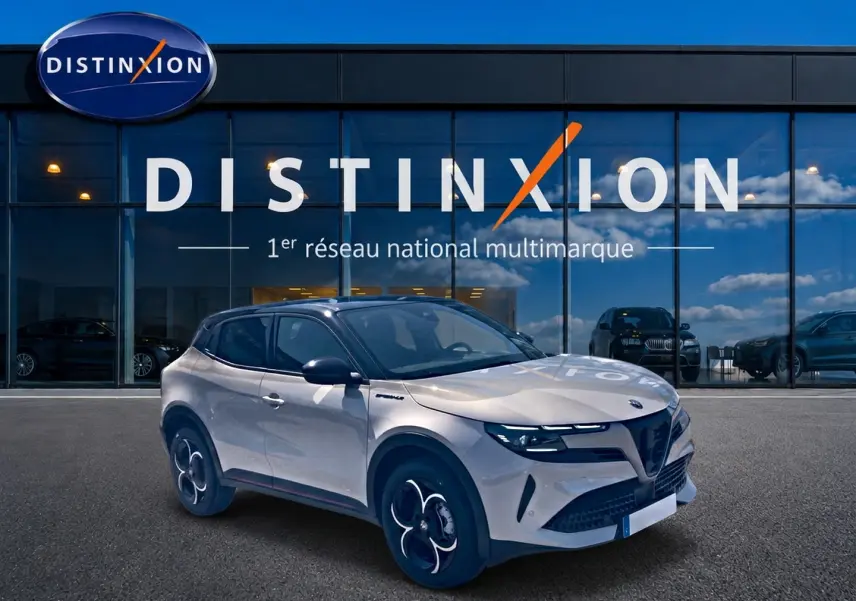 Alfa Romeo Junior 1.2 hybride 2026 vue 3/4 avant en ivoire et noir devant showroom Distinxion.