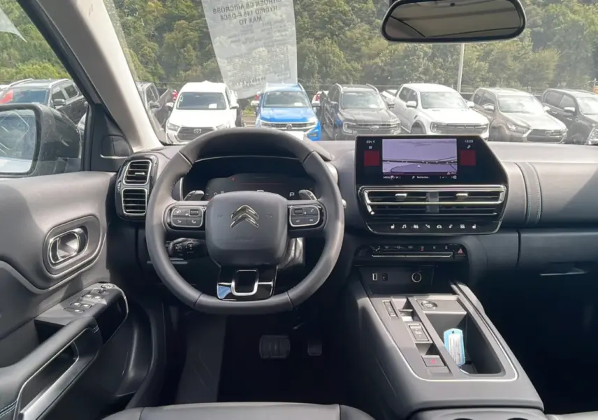 Vue intérieure du poste de conduite du Citroën C5 Aircross Hybrid 2025, avec volant multifonction et écran tactile central.