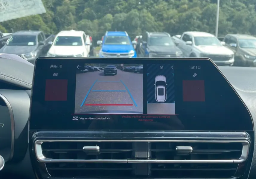 Vue arrière depuis la caméra de recul du Citroën C5 Aircross Hybrid blanc avec toit noir, affichée sur l'écran intérieur.