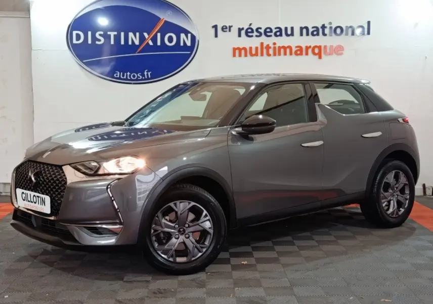 DS3 Crossback gris foncé vu de 3/4 avant droit avec phares allumés et calandre distinctive DS.