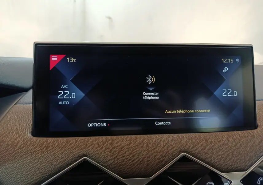 Écran tactile central du tableau de bord du DS3 Crossback gris foncé, affichant la climatisation et la connexion Bluetooth.