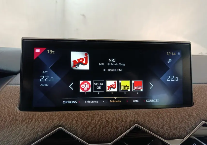 Écran tactile central du tableau de bord du DS3 Crossback gris foncé affichant la radio NRJ à 12h14