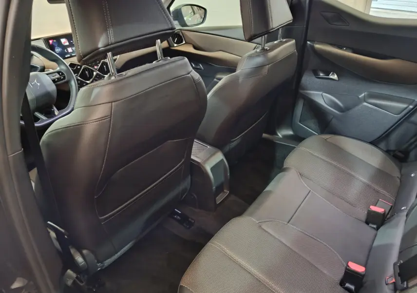 Vue intérieure arrière droite du DS3 Crossback 2020, sièges en cuir noir et tableau de bord partiellement visible.