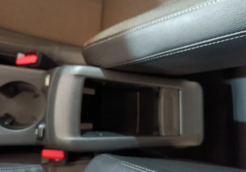 Gros plan sur la console centrale noire et les sièges en cuir gris foncé du DS3 Crossback PureTech 130 Automatique Business.