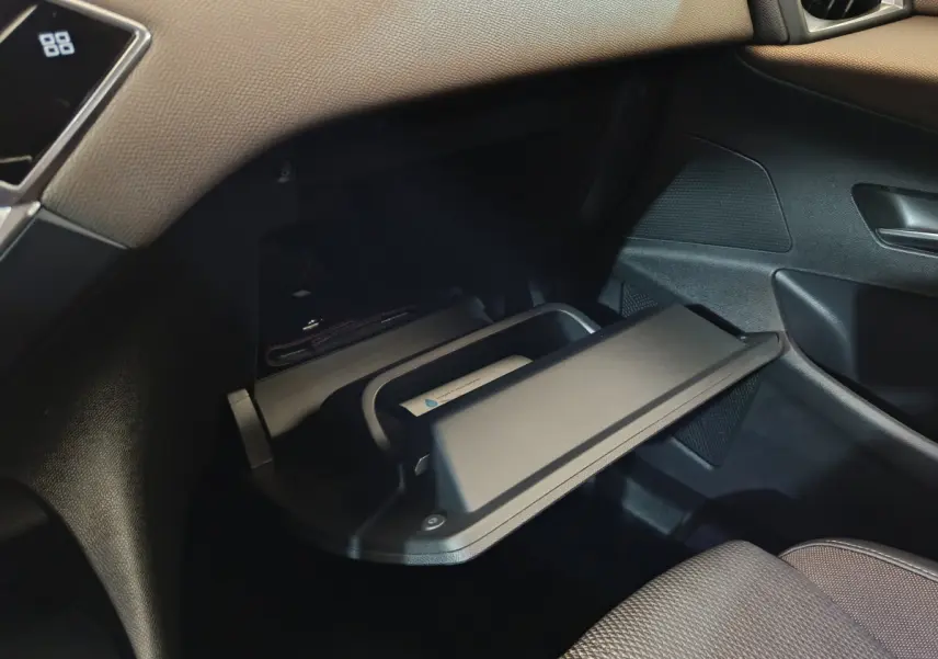 Gros plan sur la boîte à gants ouverte côté passager du DS3 Crossback gris foncé, intérieur noir texturé.