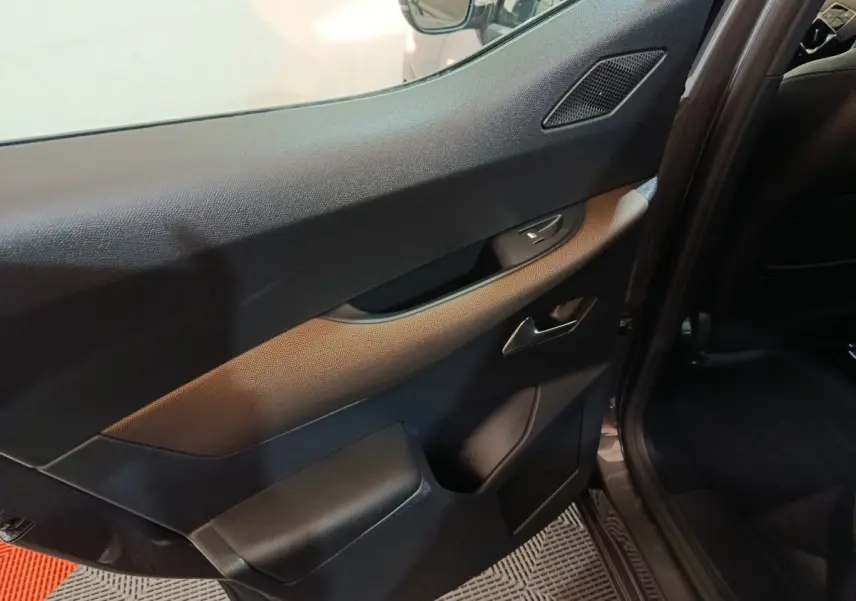 Vue rapprochée de la porte intérieure côté gauche gris foncé du DS3 Crossback 2020 avec poignée et commande de fenêtre.