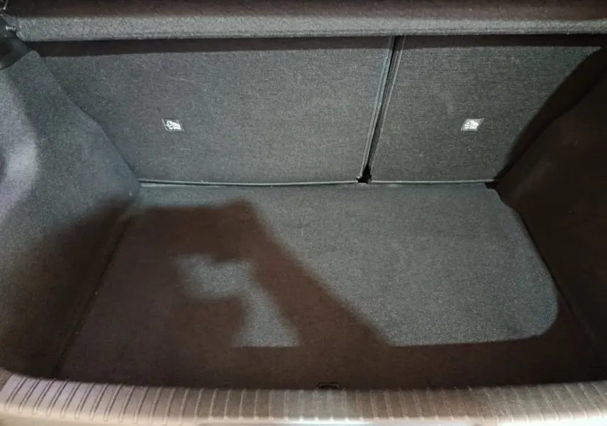 Coffre vide en vue plongeante du DS3 Crossback gris foncé, montrant la banquette arrière rabattable et le revêtement intérieur.