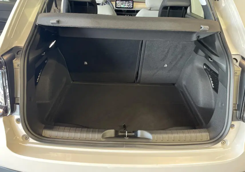 Coffre ouvert vu de l'arrière d'une FIAT 600 beige métallisé avec banquette arrière rabattable et planche de bord visible.