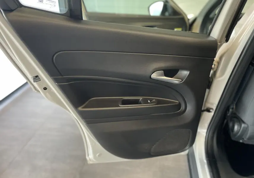 Gros plan sur la porte arrière gauche beige métallisé d'une FIAT 600 Hybrid 2025 avec poignée intérieure chromée.