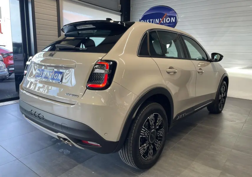 Vue 3/4 arrière droite d'une FIAT 600 beige métallisé avec jantes alliage noires et feux arrière LED distinctifs.