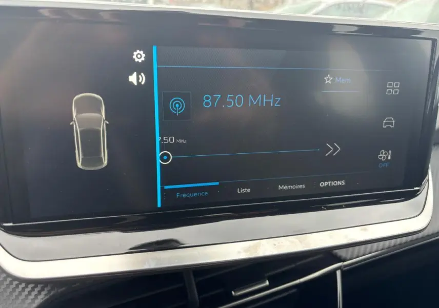 Écran tactile central du tableau de bord de la Peugeot 208 Hybrid 100 e-DCS6 Style affichant la fréquence radio 87,50 MHz.