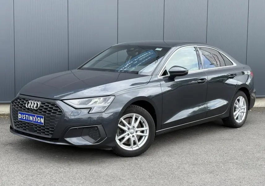 Audi A3 Berline gris métallisé vue 3/4 avant droit, avec calandre hexagonale noire et jantes argentées.