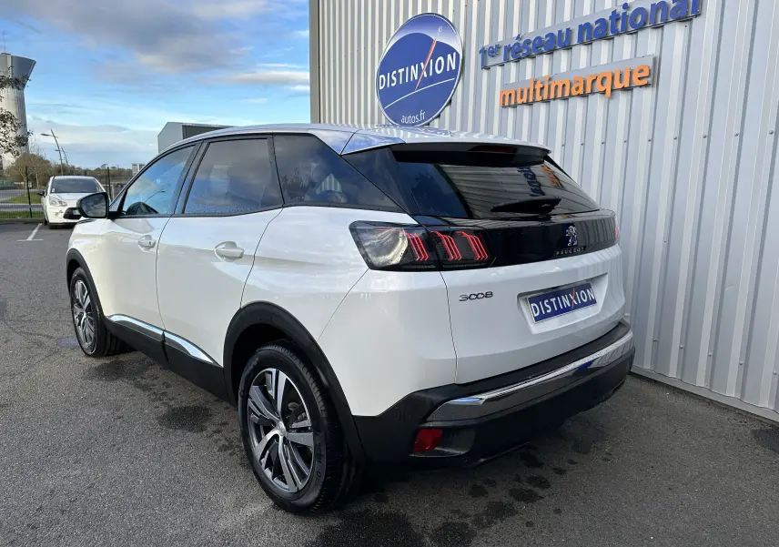Peugeot 3008 blanc nacré vu en 3/4 arrière droit, avec feux arrière à griffes et toit noir brillant.