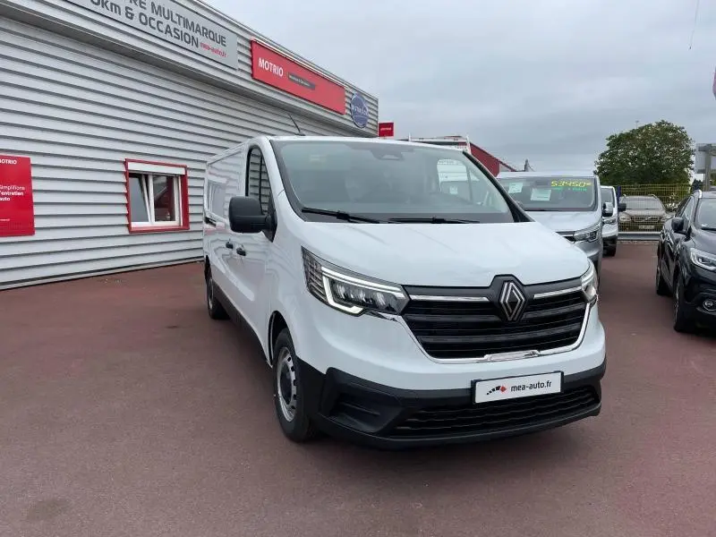 Renault Trafic Fourgon blanc Glacier vu en 3/4 avant droit, avec calandre noire et phares LED allumés.