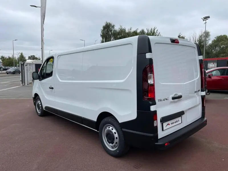 Vue 3/4 arrière droite du Renault Trafic Fourgon blanc Glacier avec portes arrière fermées sur parking extérieur.
