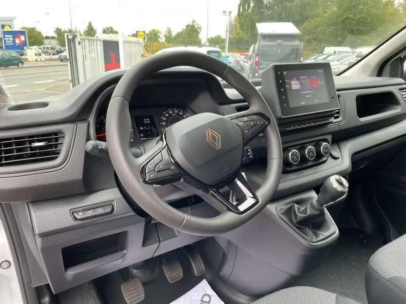 Intérieur du Renault Trafic Fourgon 2024, vue du poste de conduite avec volant multifonction et écran tactile central.