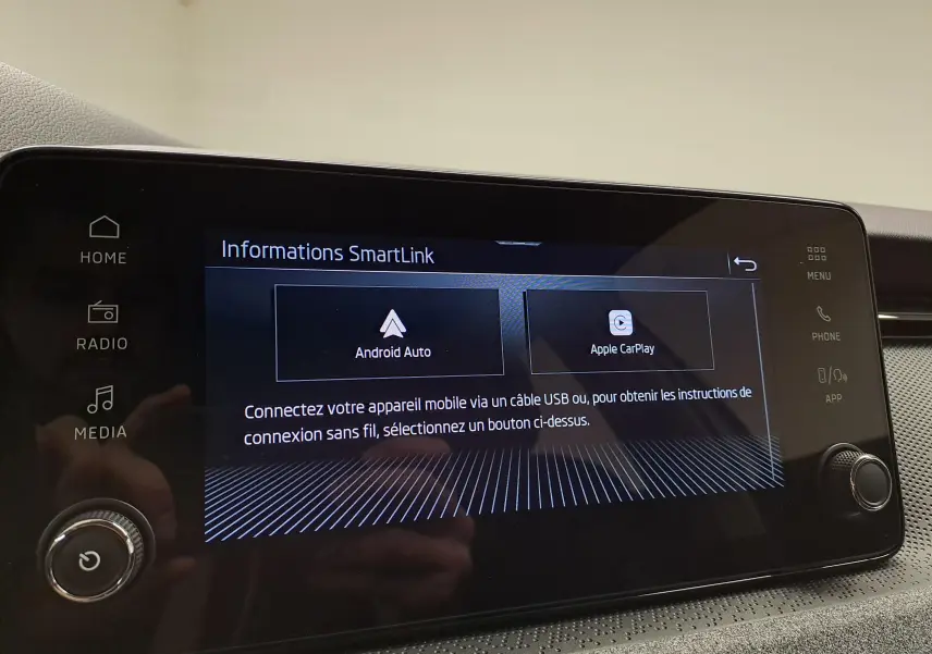 Écran tactile central du Skoda Kamiq 2025 affichant les options Android Auto et Apple CarPlay, avec commandes autour.
