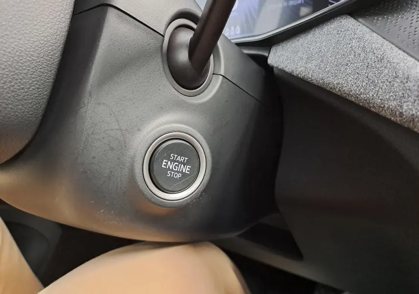 Bouton start/stop moteur en gros plan sur le tableau de bord côté gauche du Skoda Kamiq blanc Lune 2025.