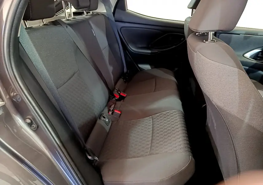 Vue intérieure du siège arrière côté gauche d'une Toyota Yaris hybride gris clair avec tissu texturé.