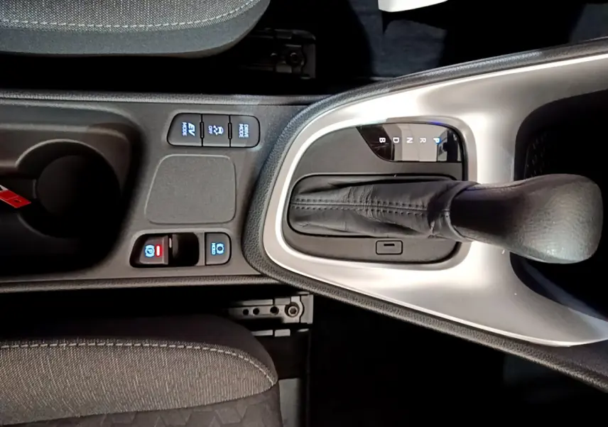 Gros plan sur la console centrale de la Toyota Yaris hybride 2021, montrant le levier de vitesse automatique et les boutons de commande.