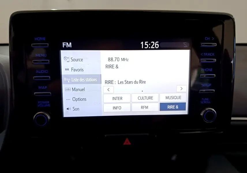 Écran tactile central de la Toyota Yaris hybride 2021 affichant la liste des stations radio FM en intérieur noir.
