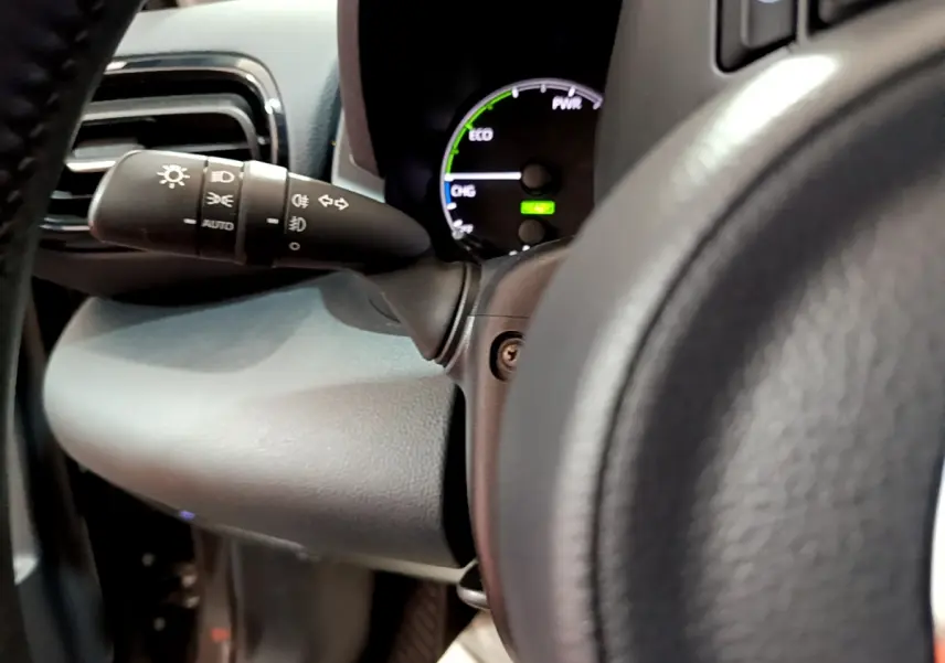 Gros plan sur le commodo d’éclairage et le tableau de bord numérique de la Toyota Yaris hybride 2021.