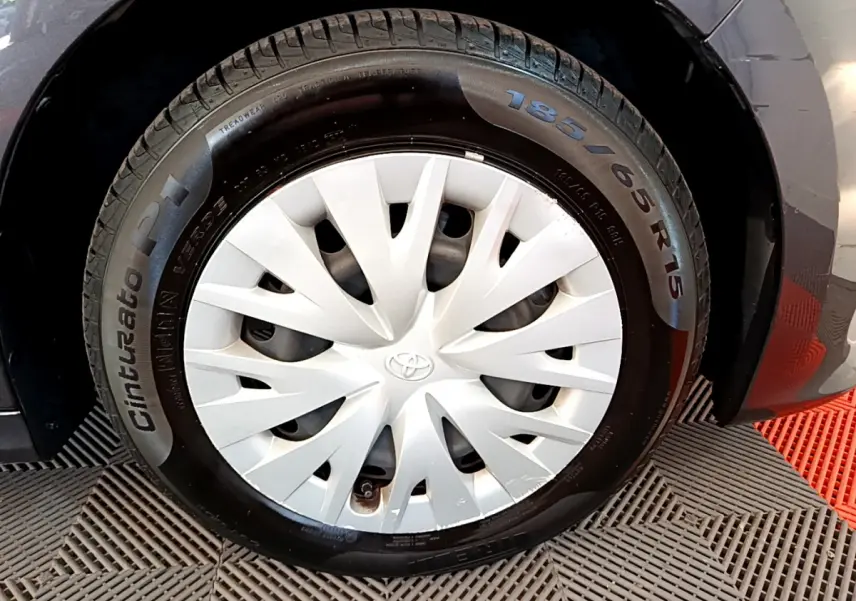 Gros plan sur la roue avant droite gris clair de la Toyota Yaris Hybride 116h avec enjoliveur blanc et pneu Cinturato P1.