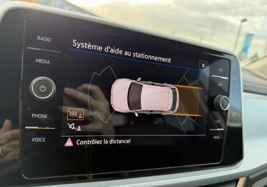Écran tactile du système d'aide au stationnement du Volkswagen T-Roc 2025 affichant une vue du dessus du véhicule.